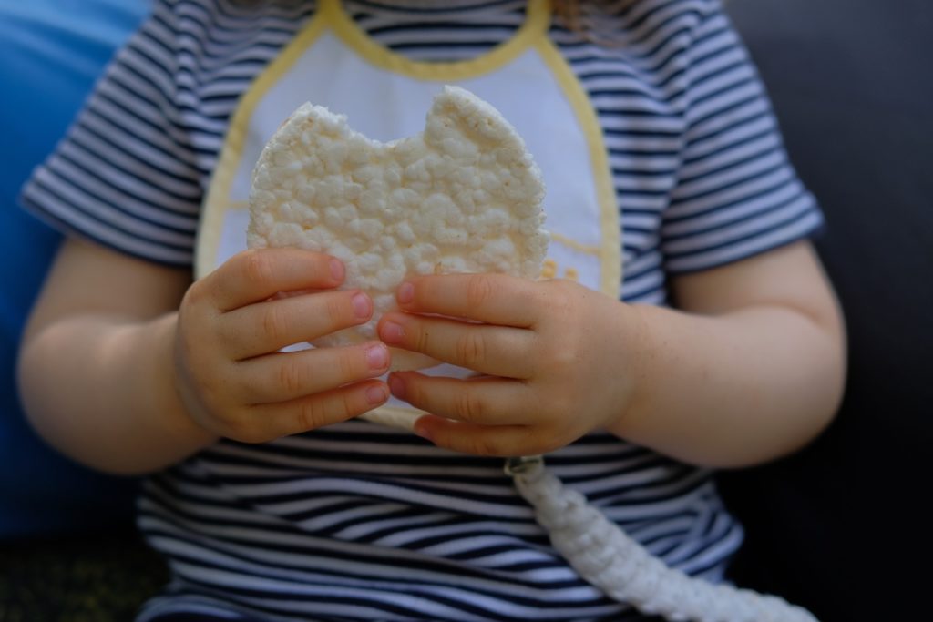 Baby holding a bitten rice cracker